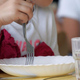 Small child eating from bowl in school cafeteria